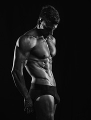 Mature athlete posing in underwear with dramatic lighting black background  black and white