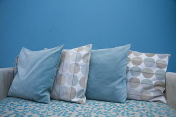 Row of pillows with blue wall background