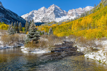 Maroon Bells and Creek in Autumn Snow - An autumn morning view of Maroon Creek, flowing down from the side of Maroon Bells, after an overnight snow storm. Aspen, Colorado, USA.
