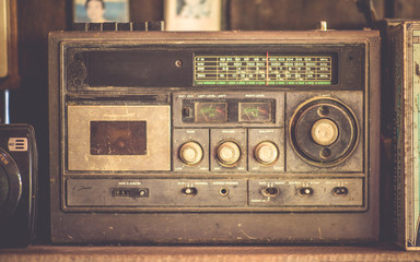 Antique rusty grunge transistor radio on a wooden shelf in vintage style. 