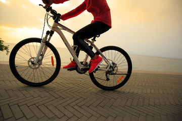 Fototapeta na wymiar one young woman riding bike on seaside