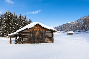 Snow covered wooden chalet in a white winter landscape