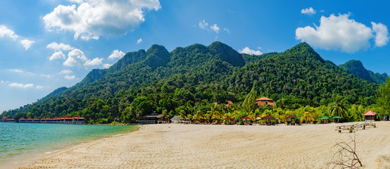Relaxing on remote paradise beach. Tropical bungalow and luxury house on untouched sandy beach with palms trees in Langkawi Island, Malaysia. - obrazy, fototapety, plakaty