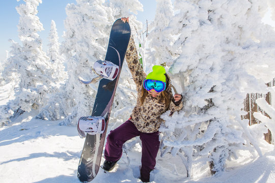 Portrait of young smiling woman with snowboard