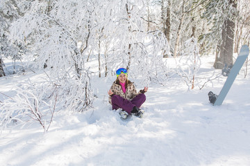 Fototapeta na wymiar Portrait of young smiling woman meditating on snow