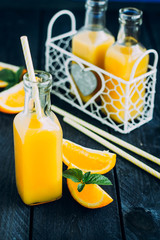 Fresh Orange juice in bottle on blue table background. Summer drink concept