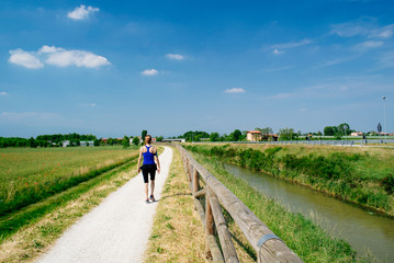 Obraz premium Fitness woman walking along a river