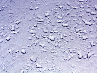 Water drops on blue car metal surface.