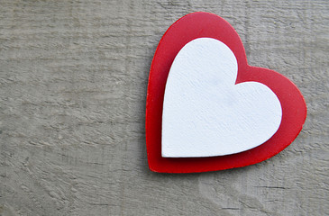 Decorative red and white wooden hearts on a grey wooden background.Two Valentine hearts.Saint Valentine's Day or Love concept.Selective focus.