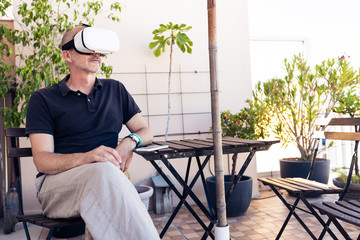 Adult Man Using Vr Goggles On His Balcony