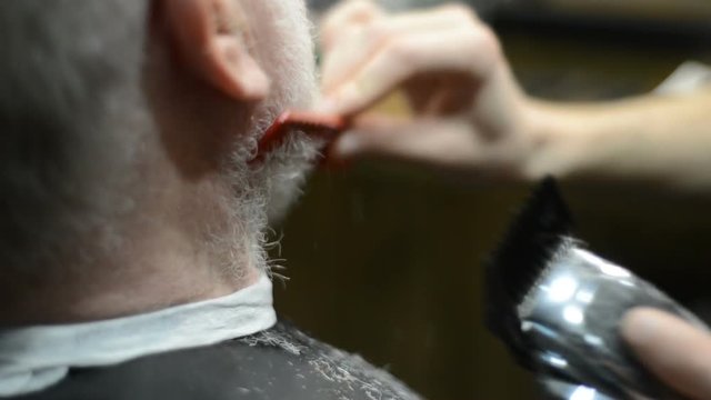 Barber cuts his beard for old man