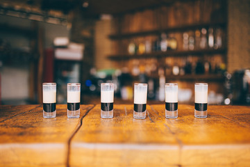 many small alcoholic cocktails b 52 on the wooden bar