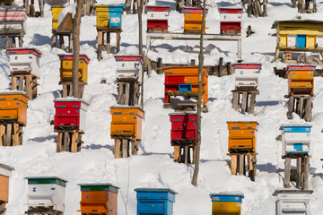 Beehives in the winter, covered with deep snow. Colorful background texture
