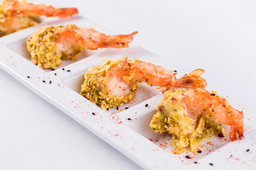 King prawns in batter in a white plate on a light background (close up )