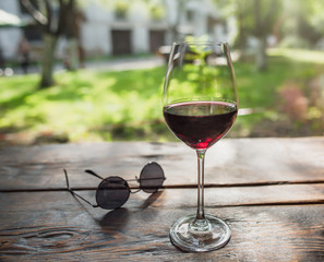 Glass of red wine infront of the summer yard