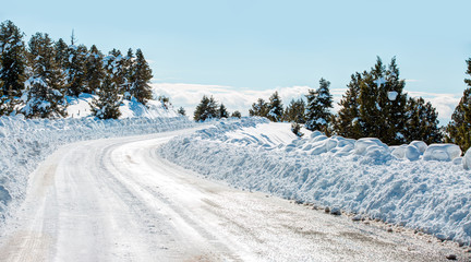 Empty snow covered road in winter landscape 