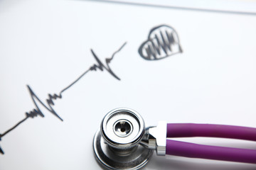 Stethoscope with cardiogram lying on desk in hospital
