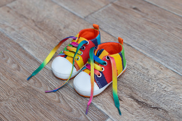 color baby shoes on wooden background