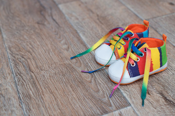 color baby shoes on wooden background