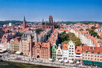 Gdansk Old City in Poland with Gothic St Mary church, Mariacka Gate, City Hall tower, historical houses and the promenade along the riverbank of Motlawa river. Aerial view