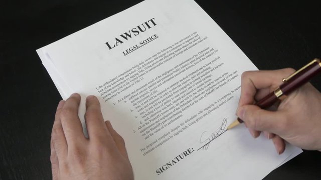 Signing a lawsuit document.