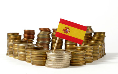 Spain flag waving with stack of money coins