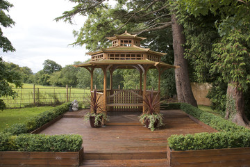 Japanese pagoda on decking in garden, summer time, landscape