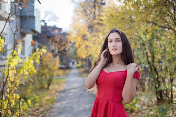 Fototapeta premium Fashionable stylish beautiful girl with long hair walks in the city