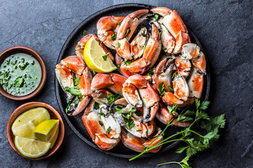 Crabs tentacles with wite wine, lemon, herbs sauce, slate background