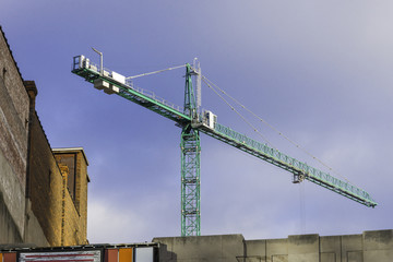Tall constructon crane high above downtown buildings
