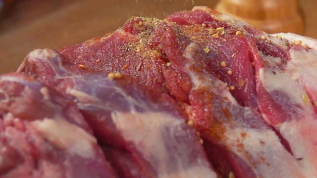 Panorama spices falls on the leg of lamb in slow motion