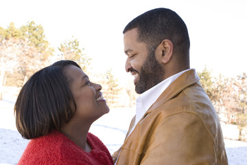 Mature African American couple laughing and hugging.