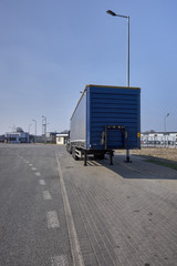 Fototapeta na wymiar Shipping containers and semi truck trailers waiting in parking lot
