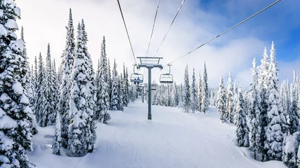 Fototapeten Riding the Chair Lift in a Winter Landscape on the Ski Hills near Sun Peaks village in the Shuswap Highlands of central British Columbia, Canada © hpbfotos