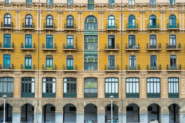Fototapeta na wymiar House facades in Bilbao along the Nervion river that runs through the city into the Cantabrian Sea. The apartment blocks are situated in the districts San Frantzisko and Bilbao la Vieja