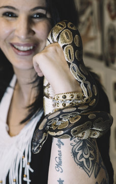 Smiling woman with snake clasping her hand