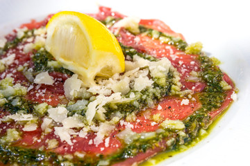 Fresh Sliced raw beef meat with leaf lettuce on the table