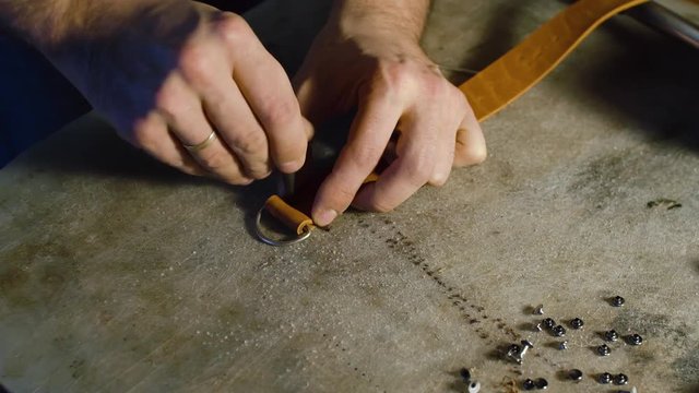 A professional re-enactment craftsman making leather item