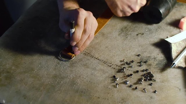 A professional re-enactment craftsman making leather item
