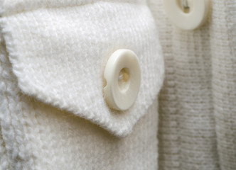 white knitted jacket with buttons. Background close-up