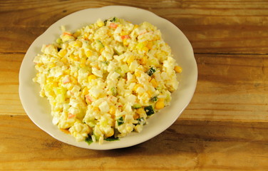 Salad with crab sticks, corn, cucumber, eggs and rice