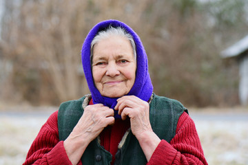Portrait of smiling old woman in blue headscarf