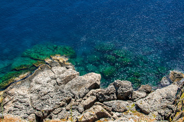 View from above on transparent blue sea water and rocks