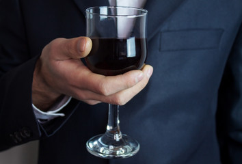 businessman holding glass of wine