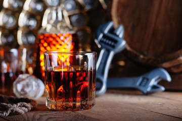 Glass of whiskey with adjustable wrenches and wooden barrel