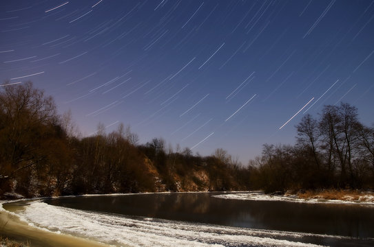 Fototapeta startrails / jasna, księżycowa, zimowa, mroźna noc nad rzeką 