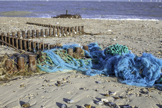 Abandoned sea fishing nets caught on a beach groyne