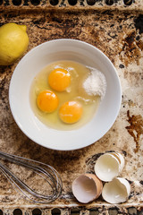 raw eggs in a bowl, whisk lemon and grater