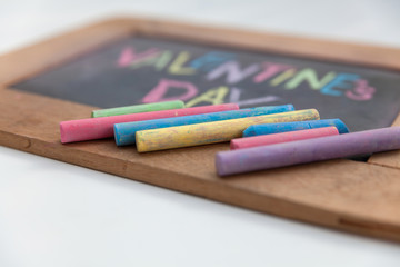 Fototapeta premium Valentines Day text handwriting on blackboard by woman