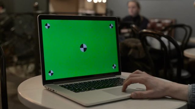 typing on a laptop with green screen